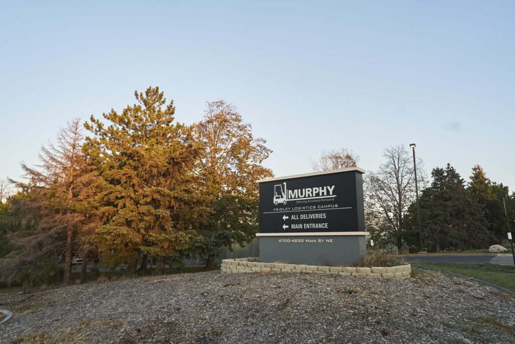 Black and Silver entrance sign to 4700-4850 Main St. Logistics Campus in Fridley, Minnesota on a sunny fall day.